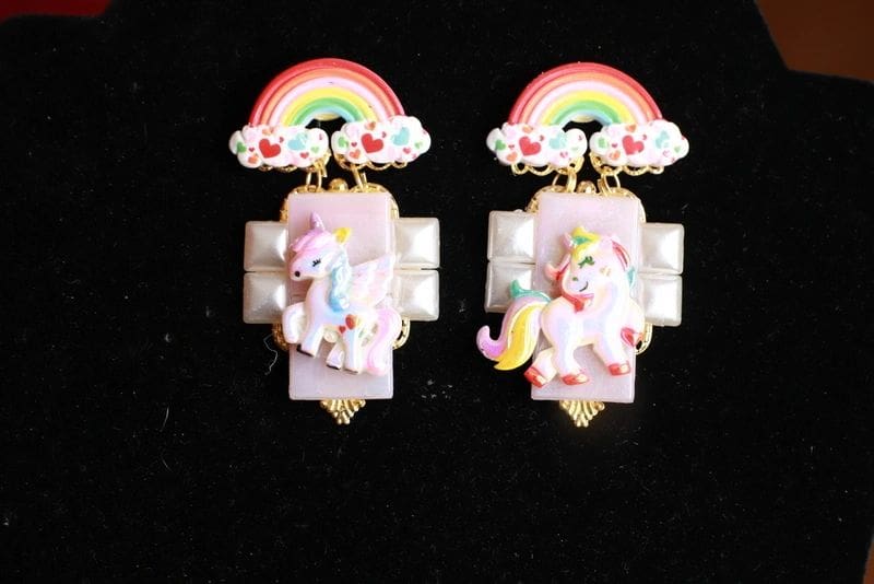 A pair of earrings with unicorns and rainbows.