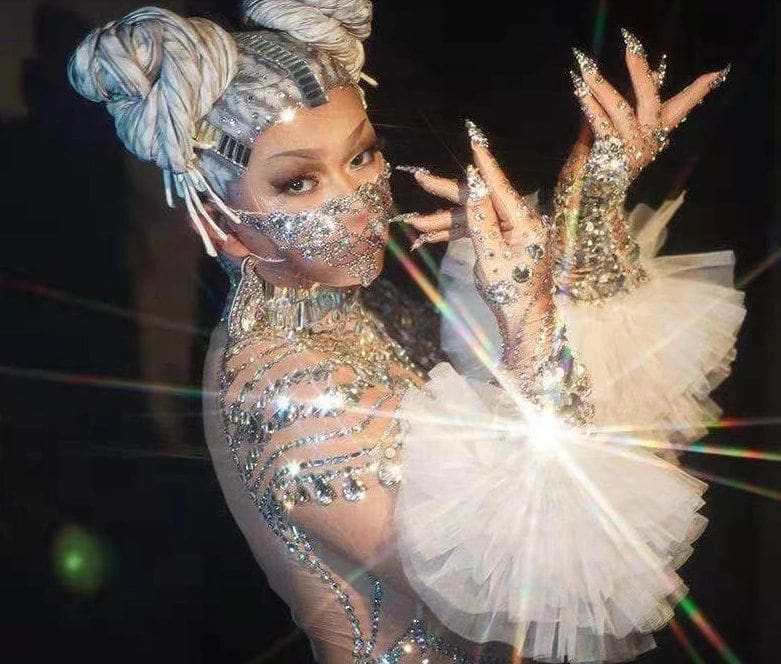 A woman in costume holding a white feather fan.