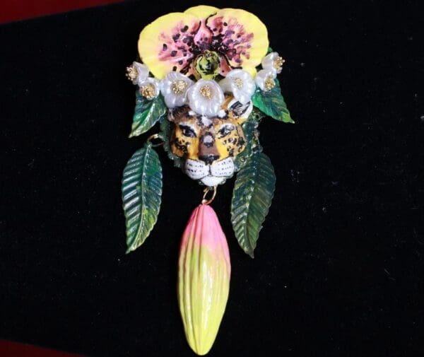 A close up of a brooch with flowers and leaves