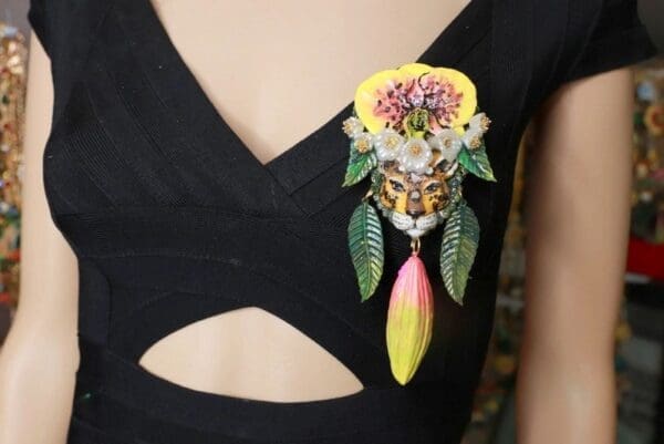 A woman wearing a black dress with a yellow and pink flower on it.
