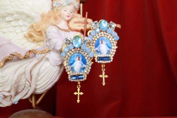 A pair of earrings with blue stones and gold crosses.