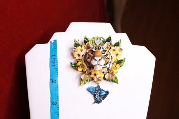 A tiger with flowers and a butterfly on it's head.