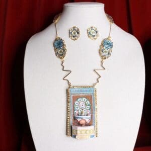A necklace and earrings set with a picture of a woman.