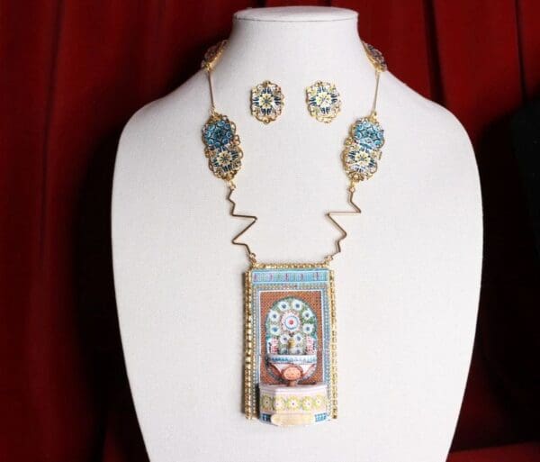 A necklace and earrings set with a picture of a woman.
