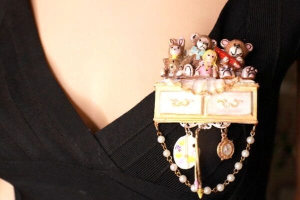 A woman wearing black and white holding a necklace with many teddy bears.