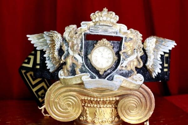 A gold and black clock on top of a pillar.
