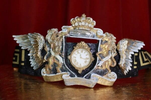 A clock with two angels and a crown on it.