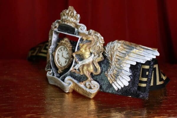 A close up of an old clock on top of a table
