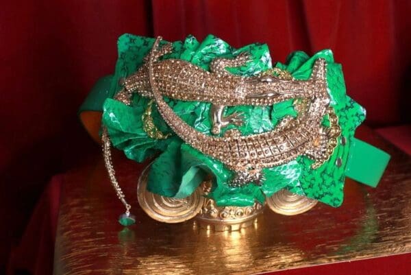 A green and gold hat with a lizard on it.