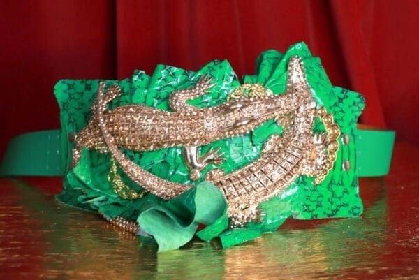 A green and gold headband with some gold beads