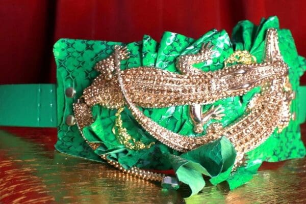 A lizard is sitting on top of a green purse.