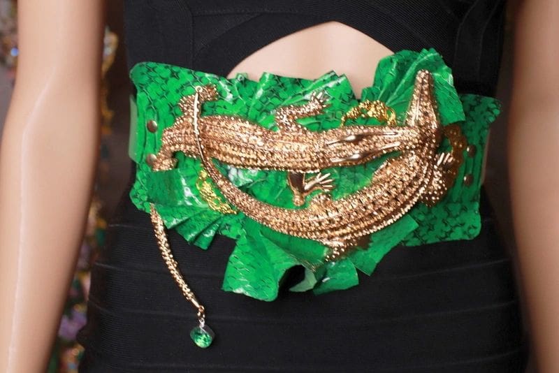 A woman wearing a green and gold belt.