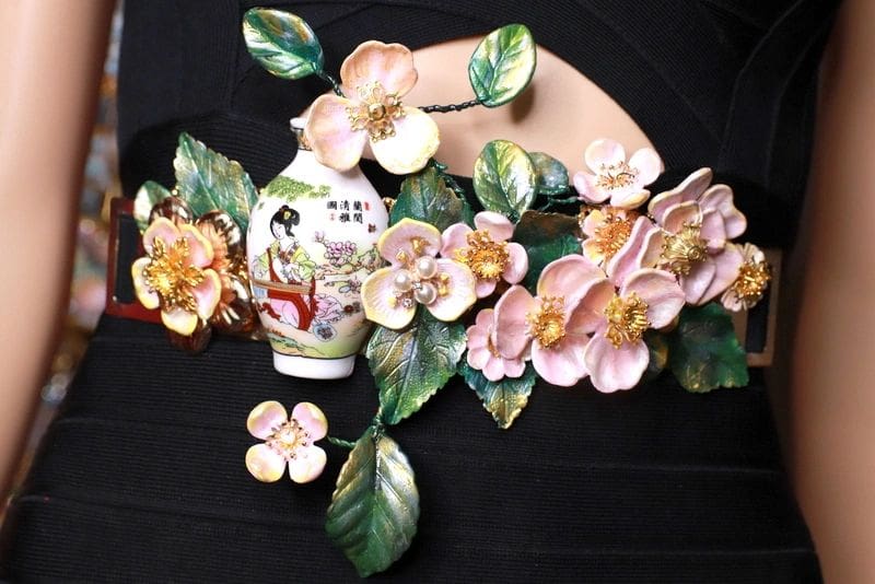 A vase with flowers and leaves on it