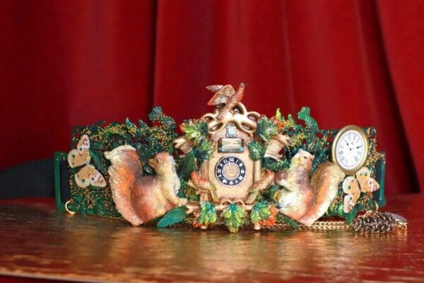 A clock with two bears on it sitting on top of a table.
