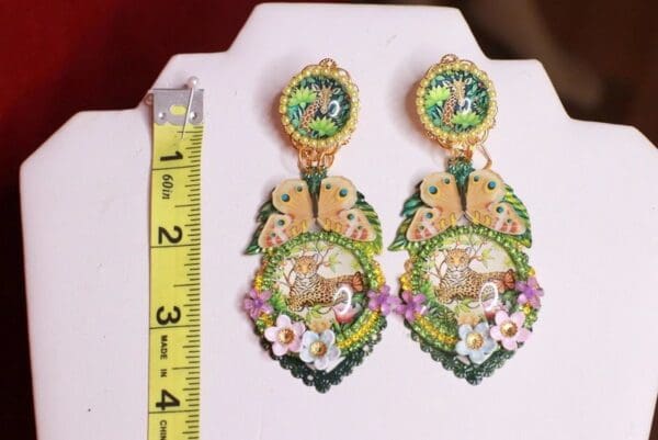 A pair of earrings with flowers and leaves.