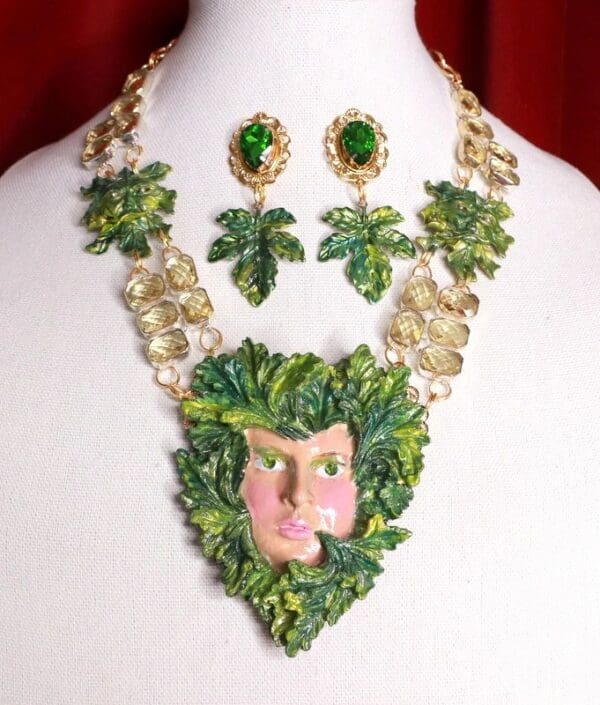 A necklace and earrings set with green leaves.