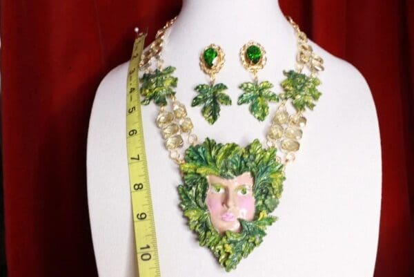 A necklace and earrings set with green leaves.