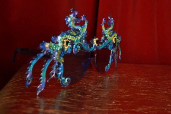 A pair of blue and yellow glasses sitting on top of a table.