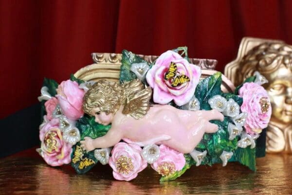 A pink pig statue with flowers in it.