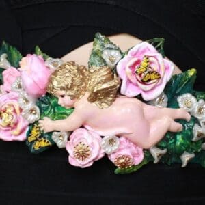 A pink angel with flowers on the side of it.