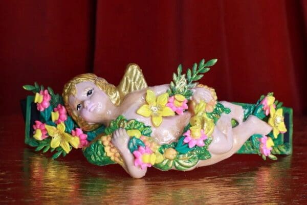 A ceramic angel with flowers on it's chest.