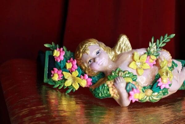 A small statue of an angel with flowers on it.