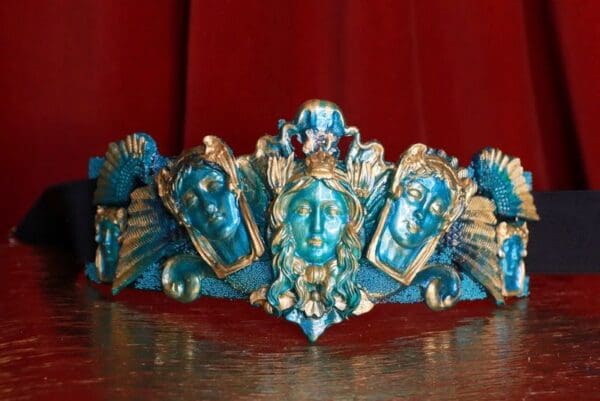 A blue and gold tiara with faces on it.
