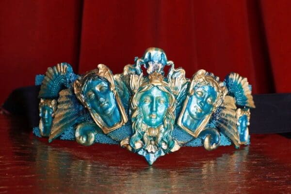 A blue and gold tiara with faces on it.