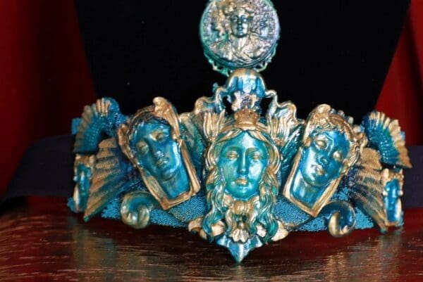 A blue and gold crown with faces on it.