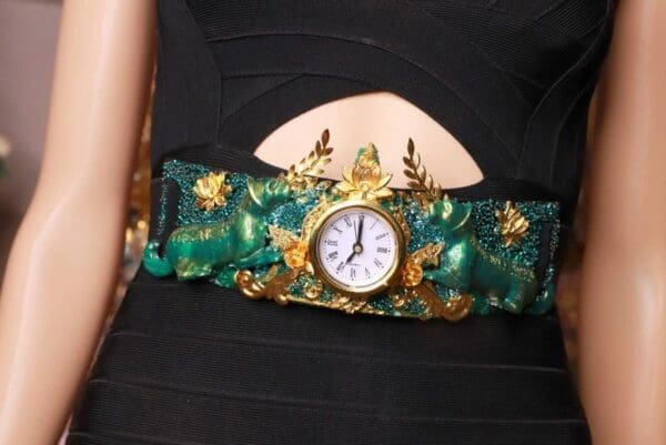A woman wearing a green and gold bracelet with a watch.