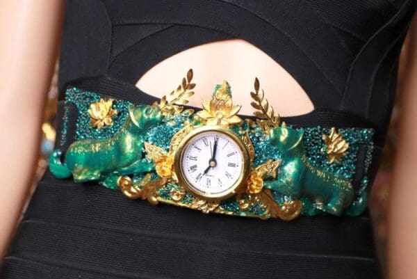A green and gold bracelet with a clock on it.