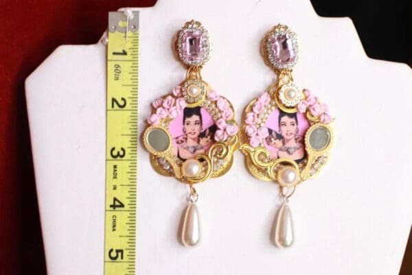 A pair of earrings with a measuring tape and ruler