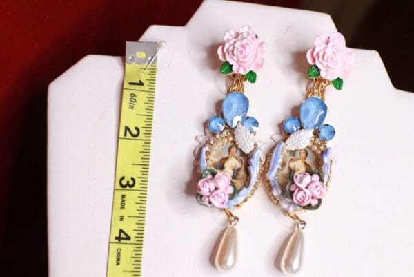 A pair of earrings with flowers and a ruler