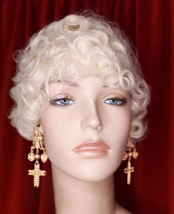 A mannequin head with blonde hair and cross earrings.