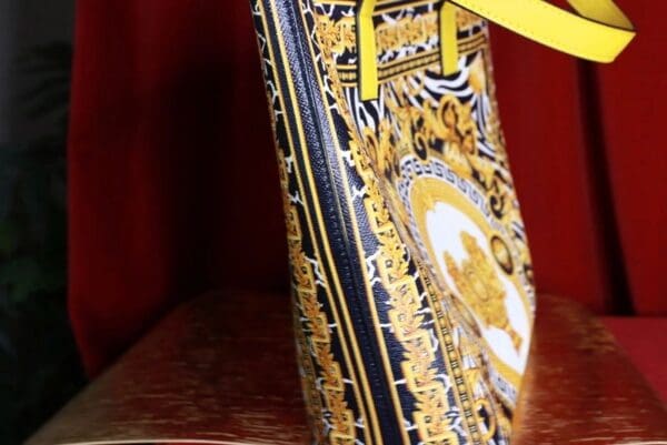 A close up of the handle on a versace bag