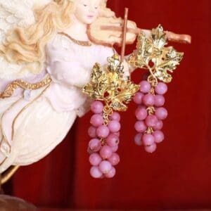 A close up of a statue with pink grapes