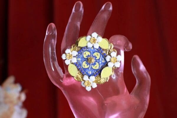 A hand holding something with a flower on it