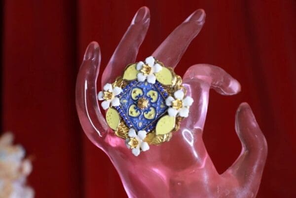 A hand holding something with flowers on it