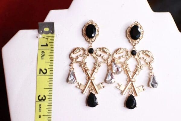 A pair of earrings with keys and black stones.