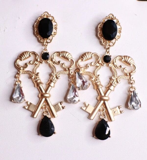 A pair of earrings with keys and black stones.