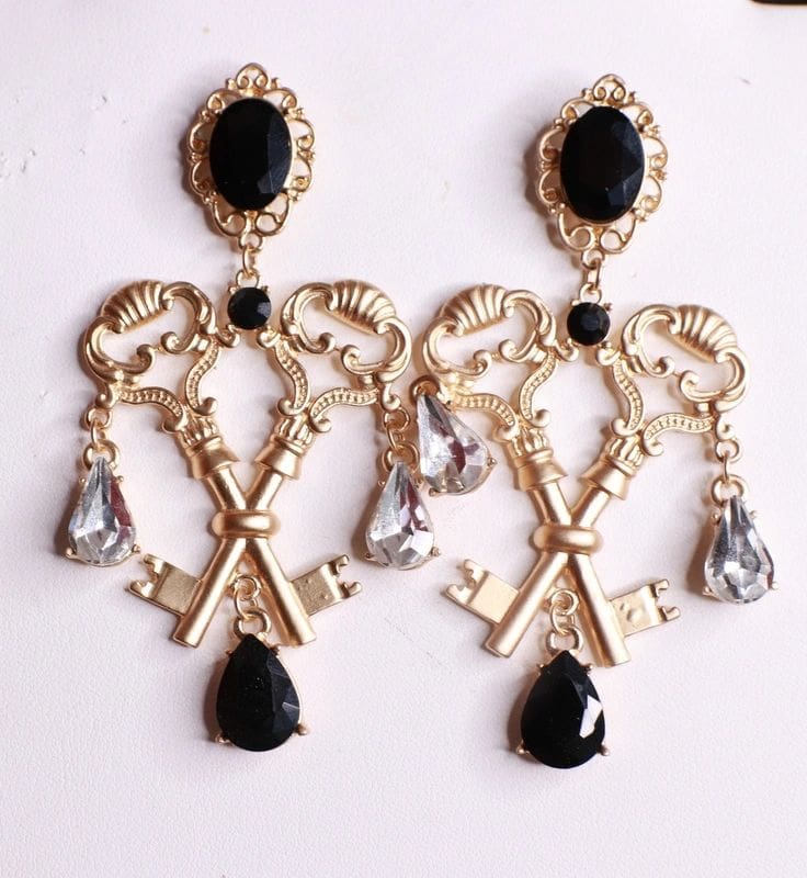 A pair of earrings with keys and black stones.