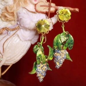 A pair of earrings with grapes hanging from them.