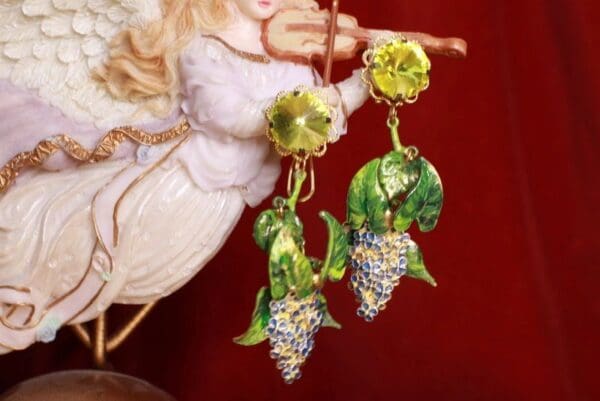 A pair of earrings with grapes hanging from them.