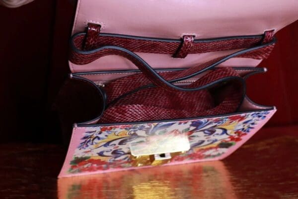 A red purse sitting on top of a wooden table.