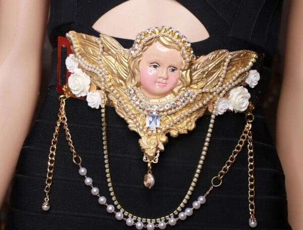 A woman wearing a necklace with a doll head on it.