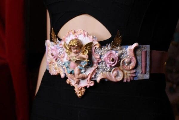 A woman wearing an elaborate belt with pink and gold decorations.