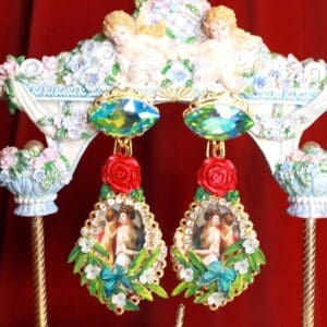 A pair of earrings with roses and pictures on them.