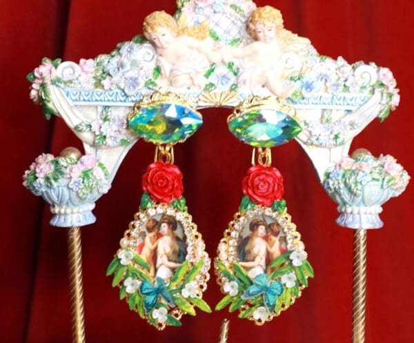 A pair of earrings with roses and pictures on them.