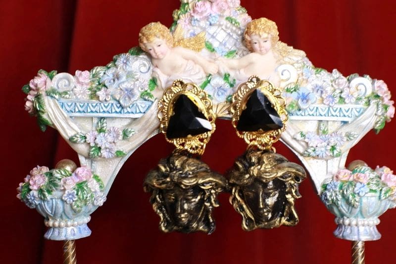 A pair of earrings with black stones and gold plated faces.