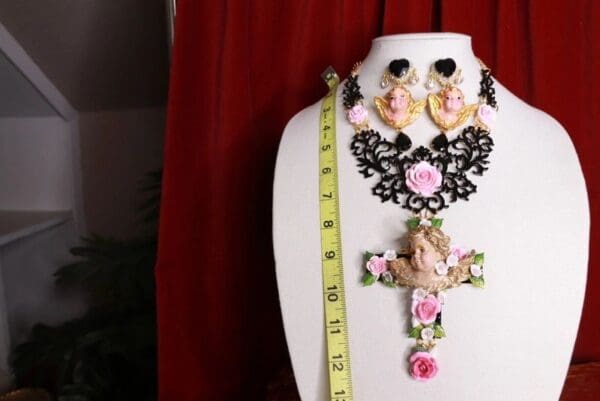 A white mannequin with a cross and pink flowers on it.
